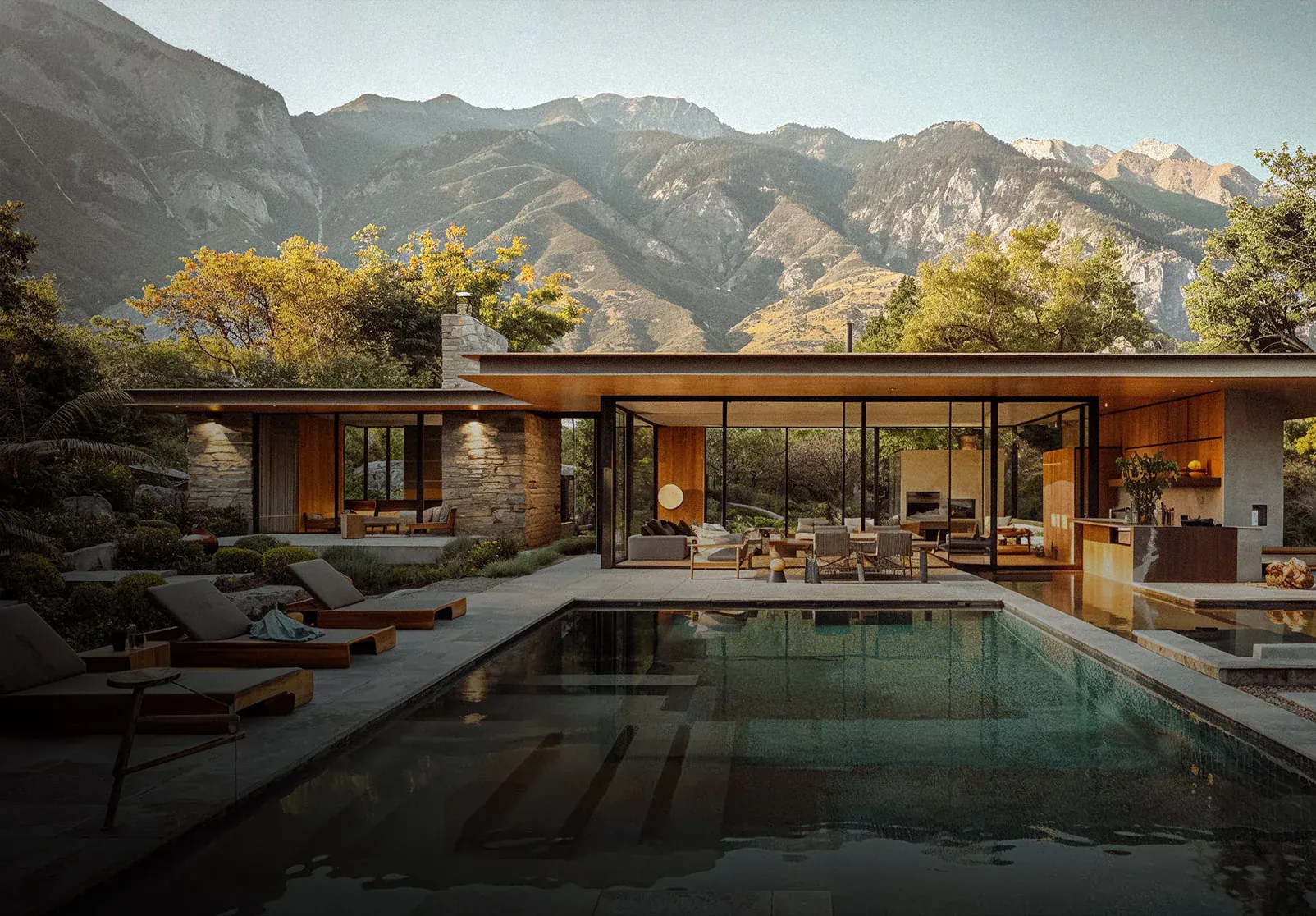 Low modern house with glowing eaves and covered terrace above a pool