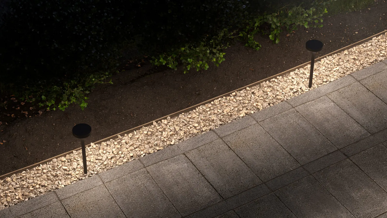 HK Radius path lights along a gravel edge and stone walk at night