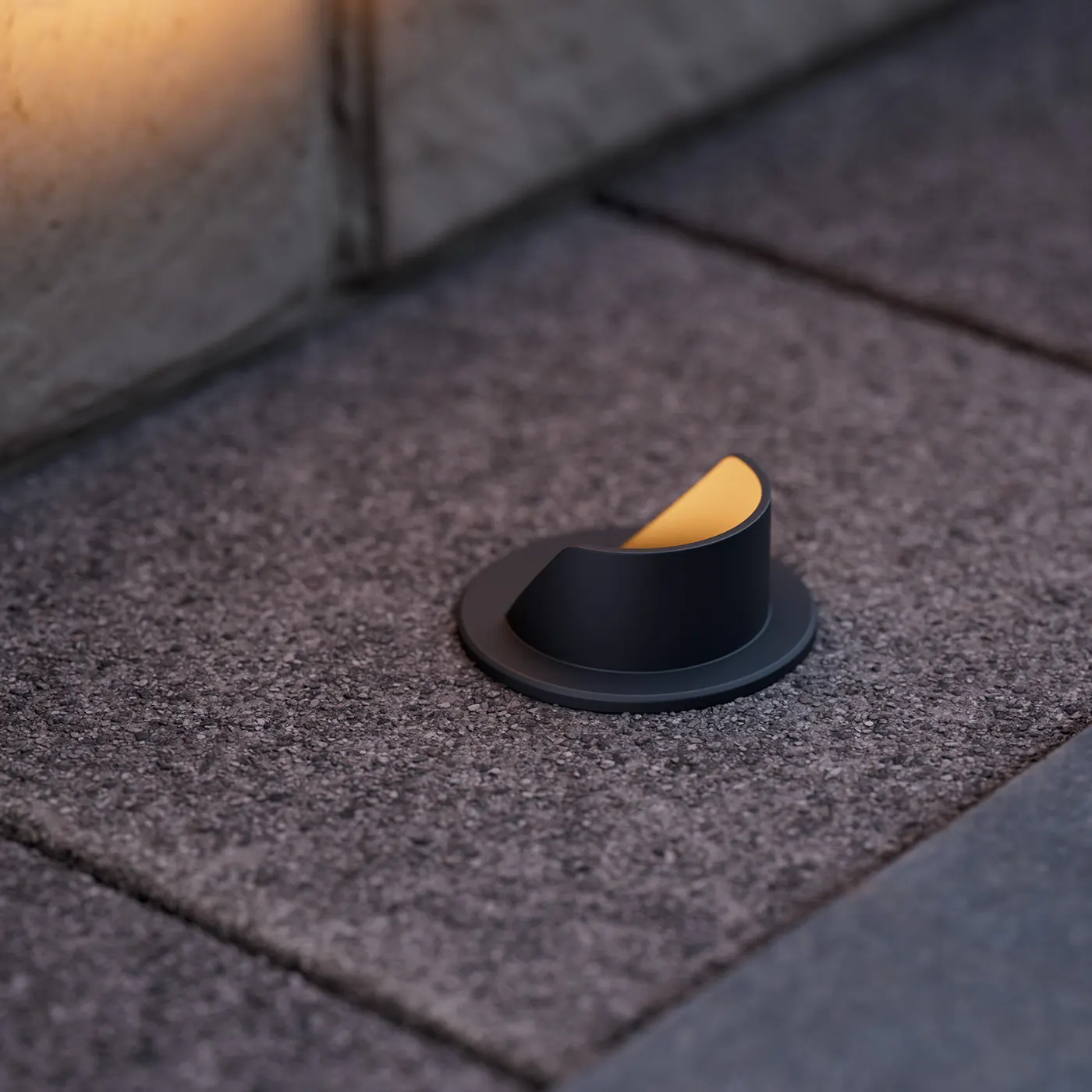 HK in-grade light with a half shield set in stone paving