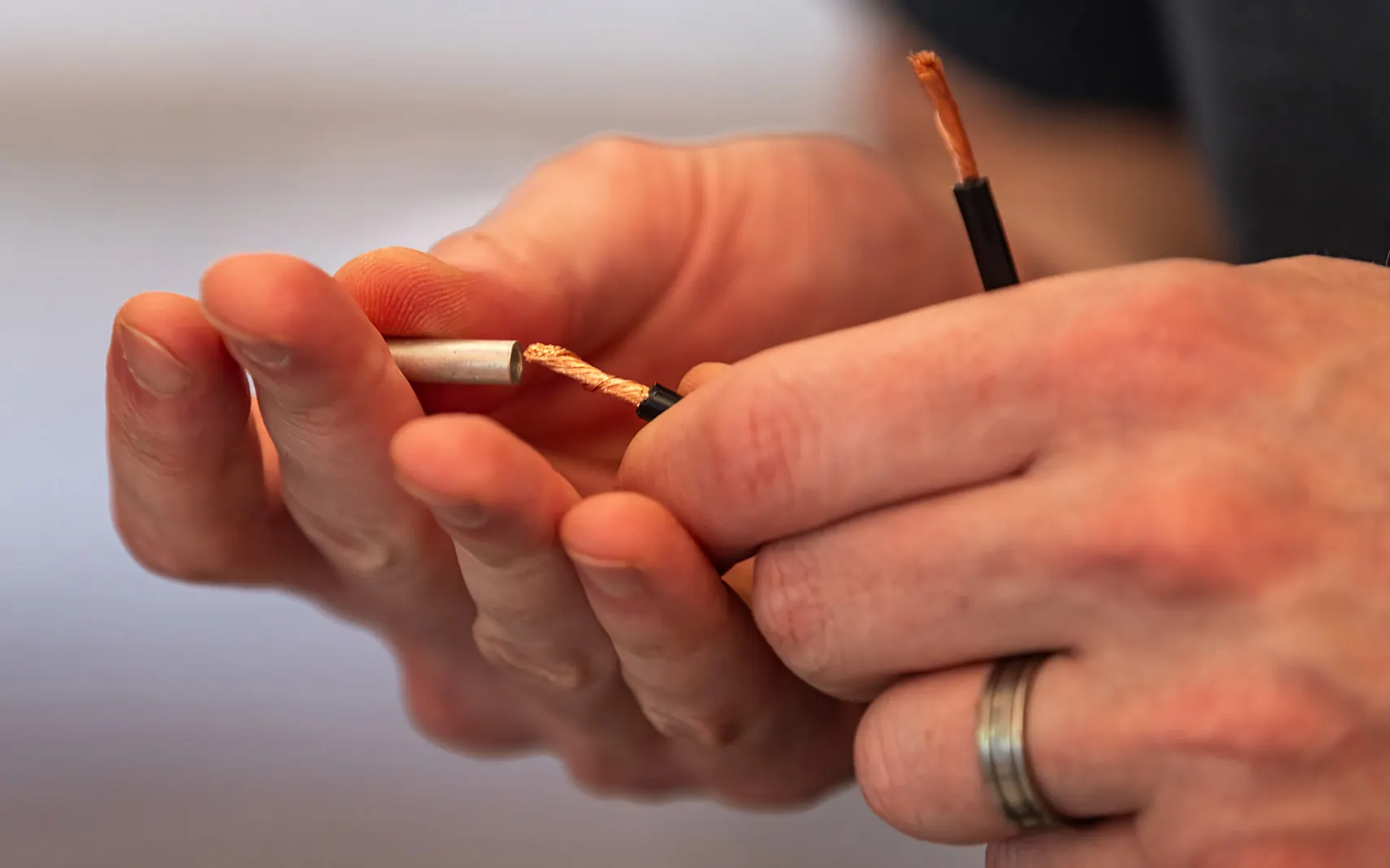 Hands stripping low-voltage landscape lighting wire